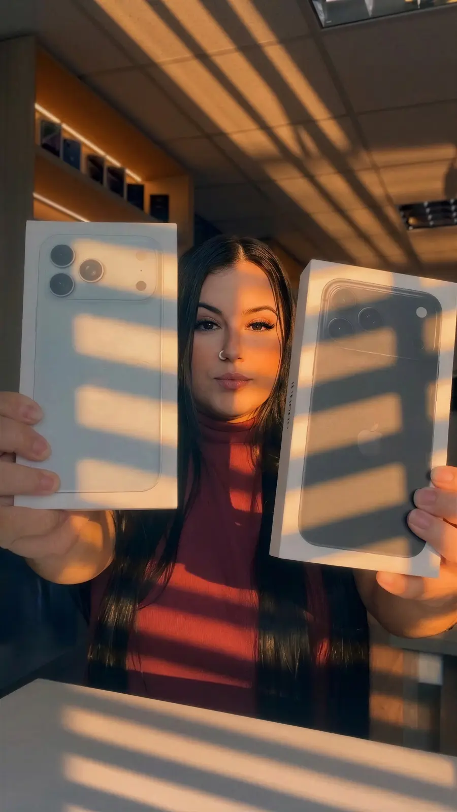 Atendente da EletroCell mostrando duas caixas de iPhone